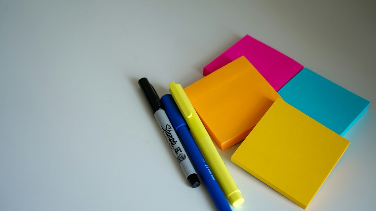 Colourful sticky notes and markers on a white desk