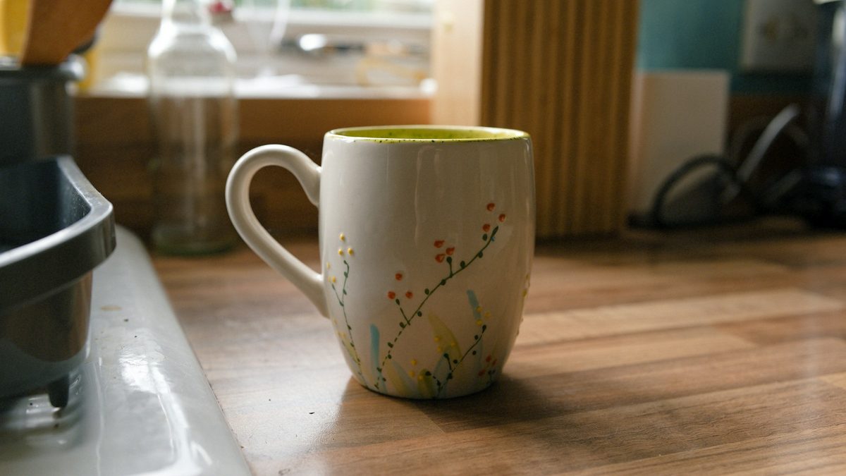 A coffee mug standing on a wooden kitchen counter